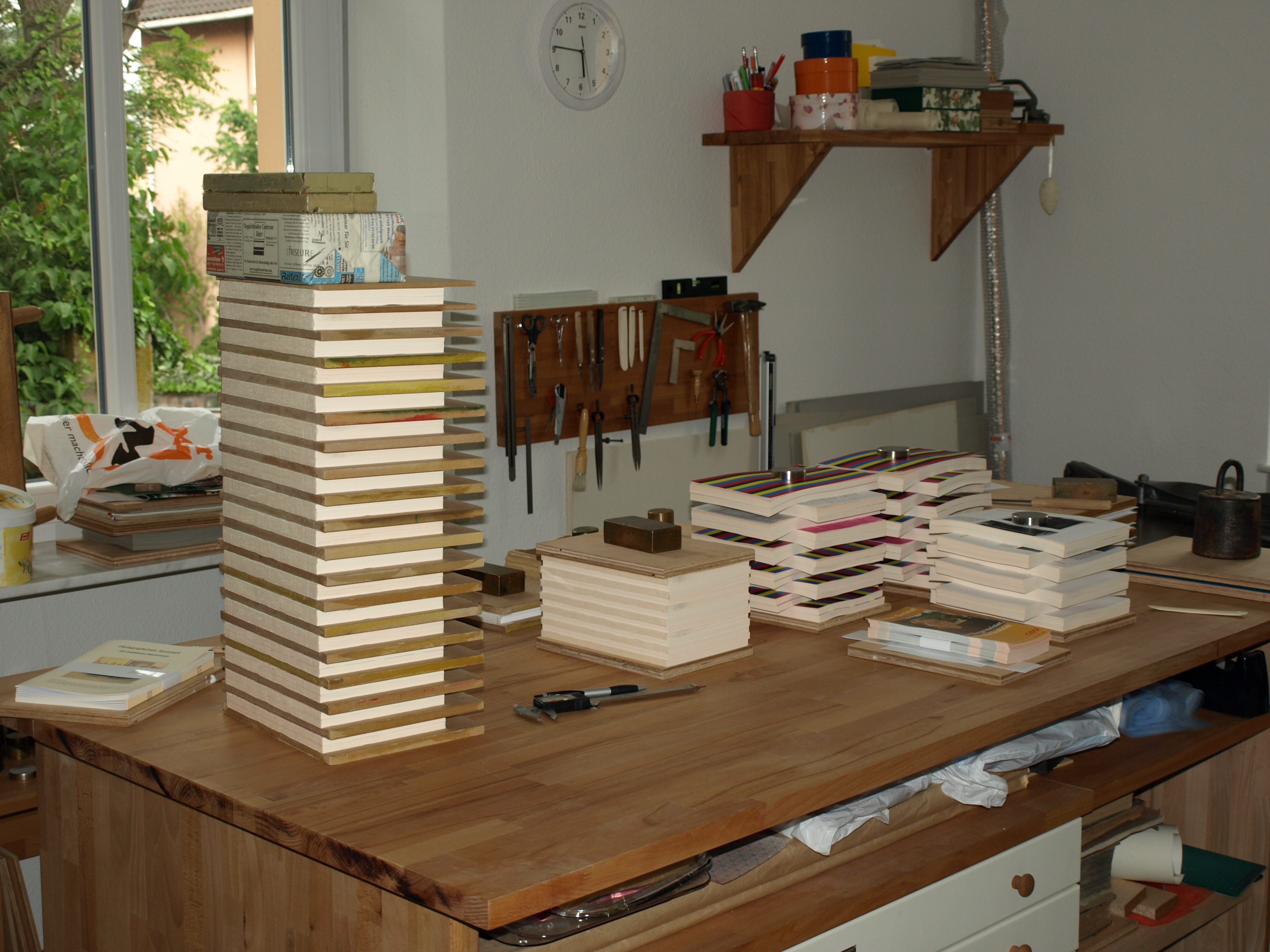 Handgebundenes Buch mit Buchbinderwerkzeugen auf einer warmen Papieroberfläche